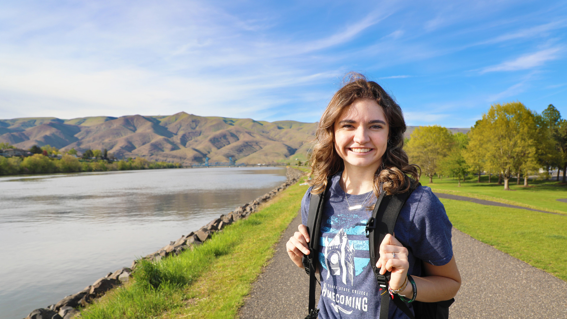 Female student outside with Snake River and hills in background